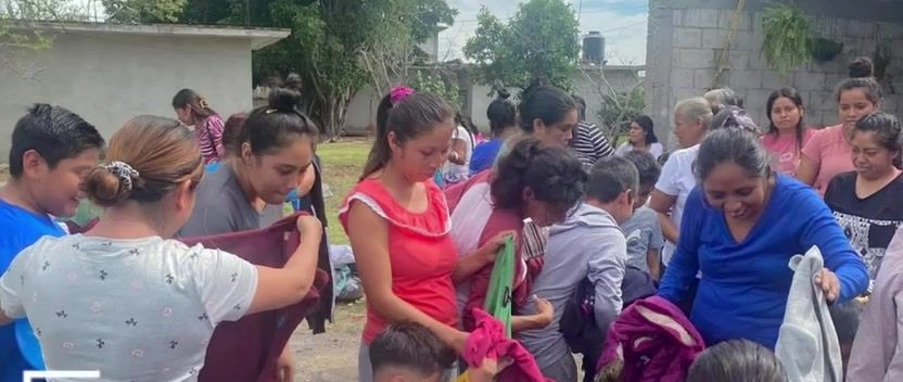 Entrega de ropa y artículos a mujeres, niñas y niños en una comunidad.